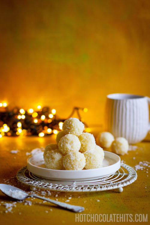 A stack of the coconut balls, with a cup of tea.