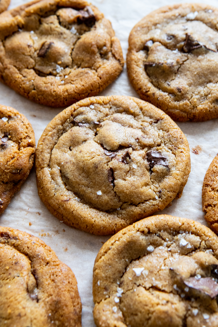 chocolate chip cookies, many on a sheet, one in focus