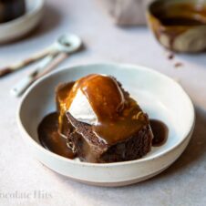 Picture of chocolate sticky toffee pudding piece with ice cream and toffee sauce (pouring shot)