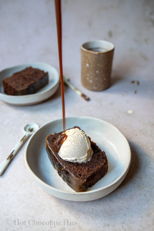Picture of chocolate sticky toffee pudding piece with ice cream and toffee sauce (pouring shot)
